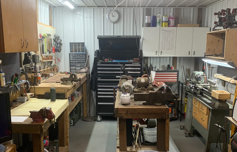 The shop interior: workbenches, a rifle rack, and organized equipment.